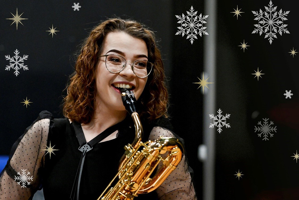 A female saxophonist, smiling